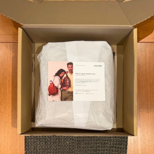 La caja abierta, con la tarjeta de agradecimiento sobre el papel de seda